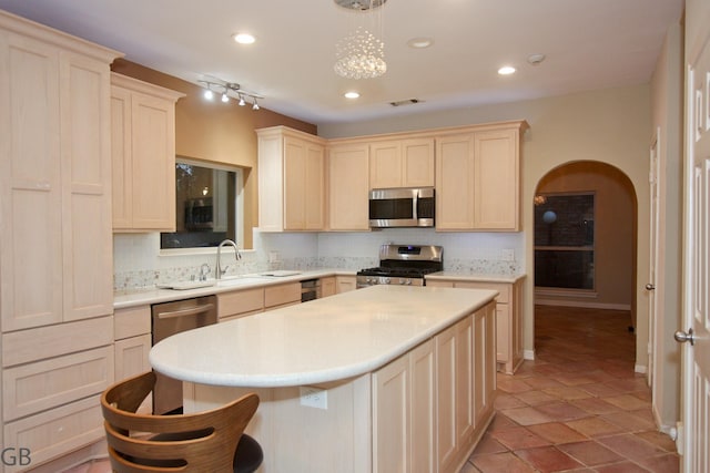 kitchen featuring appliances with stainless steel finishes, decorative backsplash, sink, and pendant lighting