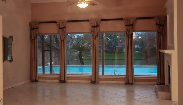 entryway featuring a healthy amount of sunlight, light tile patterned floors, and ceiling fan