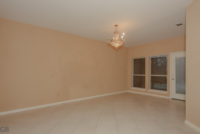 spare room with light tile patterned flooring and a chandelier