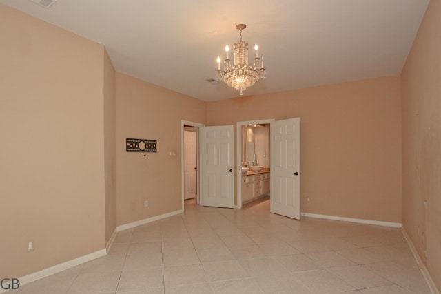 tiled empty room featuring a notable chandelier