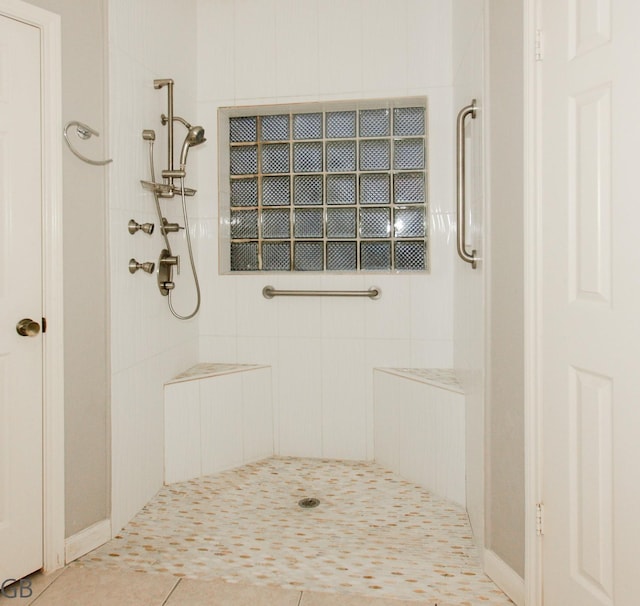 bathroom featuring a tile shower and tile patterned flooring