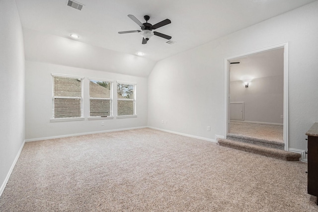 carpeted empty room with vaulted ceiling and ceiling fan