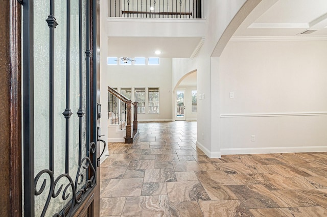 entryway featuring ornamental molding and a high ceiling