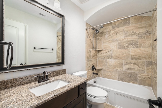 full bathroom with vanity, tiled shower / bath combo, and toilet