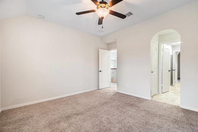 carpeted empty room with vaulted ceiling and ceiling fan