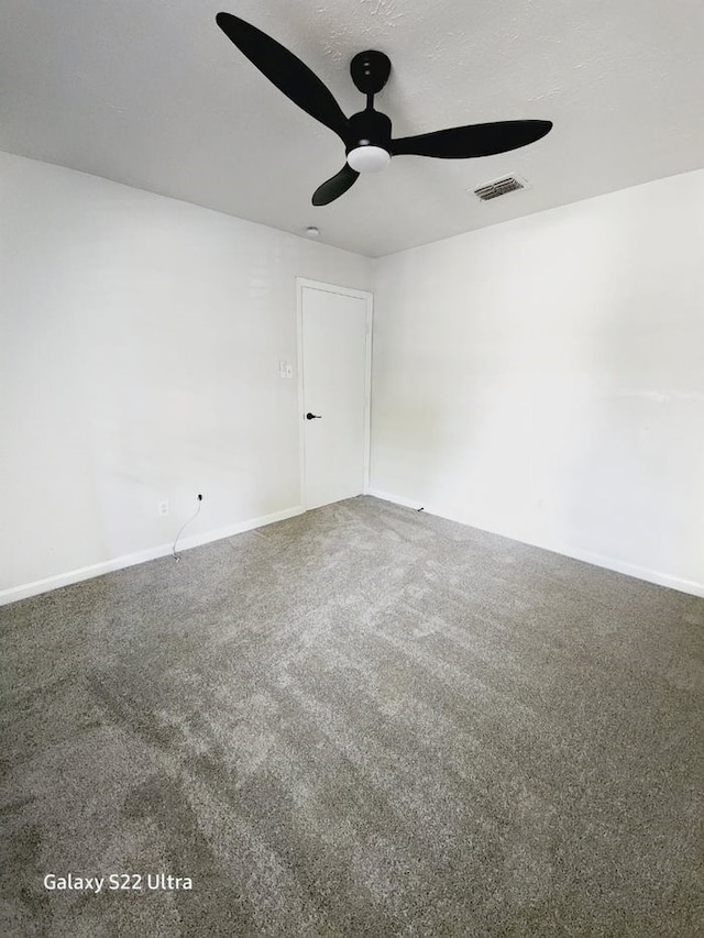 carpeted empty room with ceiling fan and a textured ceiling