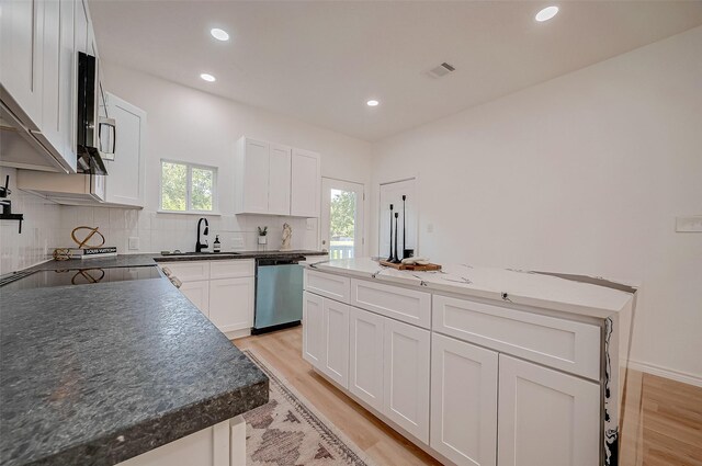 kitchen with white cabinetry, appliances with stainless steel finishes, a center island, and sink