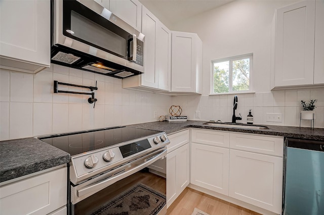 kitchen with white cabinetry, sink, and stainless steel appliances