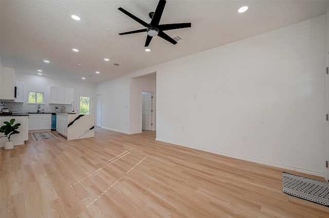 living room with ceiling fan, sink, and light hardwood / wood-style floors