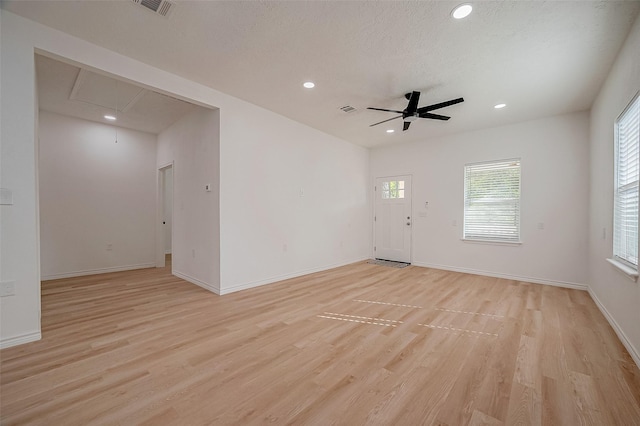 unfurnished room featuring ceiling fan, light hardwood / wood-style floors, and a textured ceiling