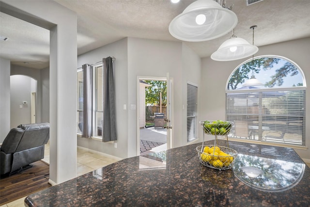 dining space featuring a textured ceiling and light hardwood / wood-style flooring