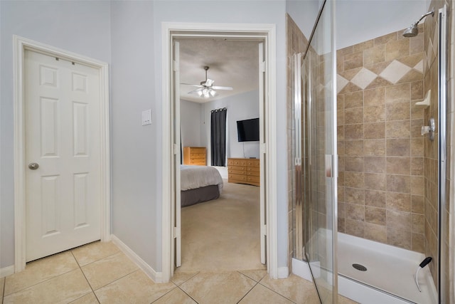 bathroom with tile patterned flooring, a shower with door, and ceiling fan