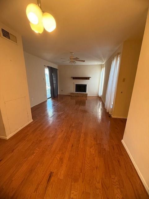 unfurnished living room featuring hardwood / wood-style flooring and ceiling fan