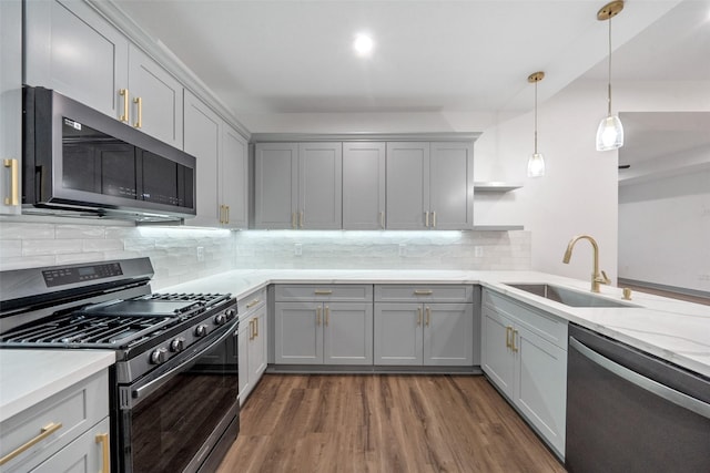 kitchen featuring pendant lighting, sink, gray cabinets, stainless steel appliances, and dark hardwood / wood-style flooring