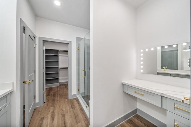 bathroom featuring vanity, wood-type flooring, and a shower with shower door