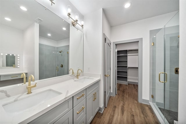 bathroom featuring walk in shower, wood-type flooring, and vanity