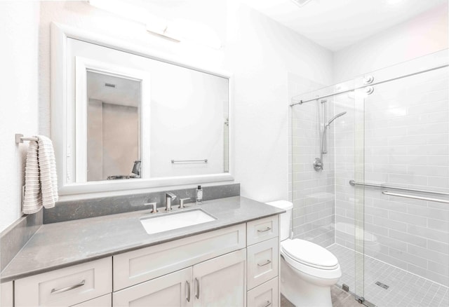 bathroom with toilet, vanity, and an enclosed shower