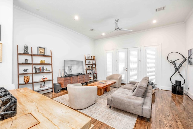 living room featuring ceiling fan, wood-type flooring, and ornamental molding