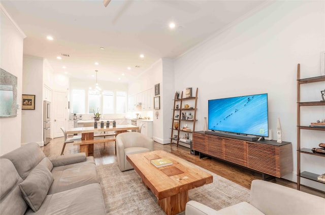 living room featuring light wood-type flooring and ornamental molding