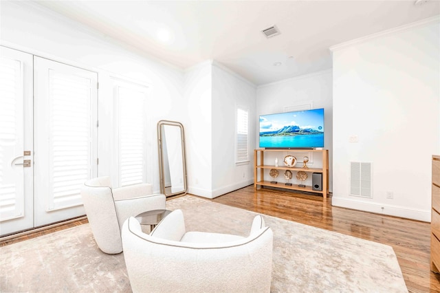 living room with wood-type flooring and ornamental molding