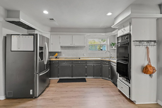 kitchen with gray cabinets, sink, light wood-type flooring, and stainless steel appliances