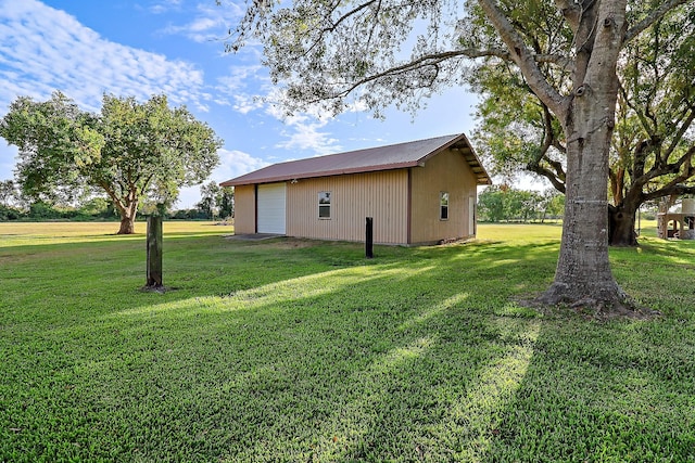 view of side of property with an outbuilding, a yard, and a garage