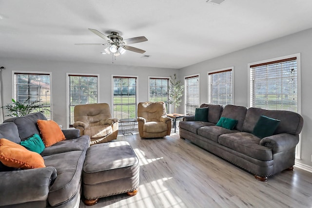 living room with light hardwood / wood-style flooring and ceiling fan