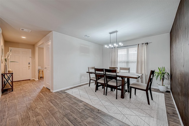 dining space with a chandelier and light hardwood / wood-style floors