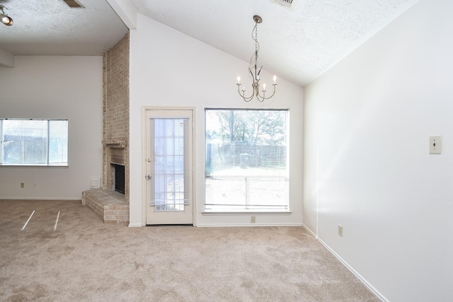 1478 Willow Wisp Dr, Missouri City, TX 77489 - unfurnished living room with a textured ceiling, carpet floors, a chandelier, healthy amount of natural light, and a brick fireplace
