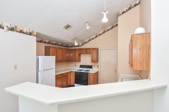 1478 Willow Wisp Dr, Missouri City, TX 77489 - kitchen with gas stove, freestanding refrigerator, a textured ceiling, light countertops, and a peninsula