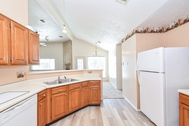 1478 Willow Wisp Dr, Missouri City, TX 77489 - kitchen featuring white appliances, a textured ceiling, a sink, lofted ceiling, and a peninsula