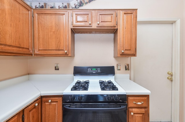 1478 Willow Wisp Dr, Missouri City, TX 77489 - kitchen featuring gas range, light countertops, and brown cabinetry