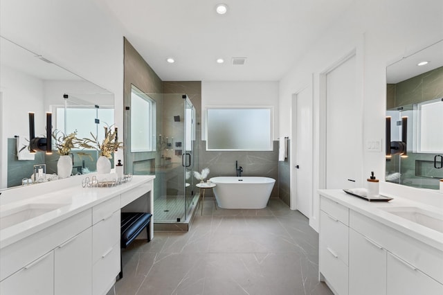 bathroom with vanity, plus walk in shower, and tile walls