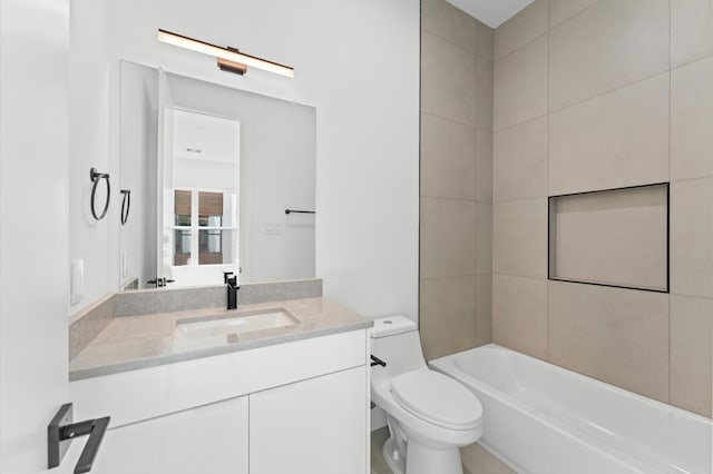 full bathroom featuring tiled shower / bath, vanity, and toilet