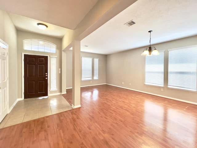 foyer entrance with a notable chandelier and light wood-type flooring