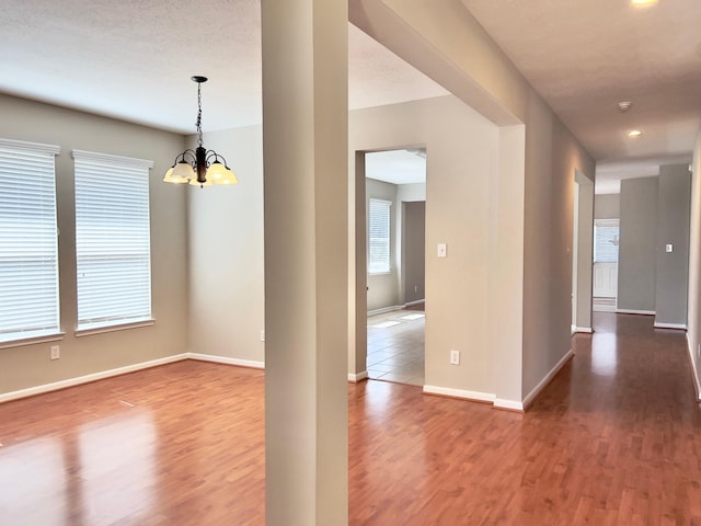 interior space featuring a healthy amount of sunlight, hardwood / wood-style floors, and a chandelier