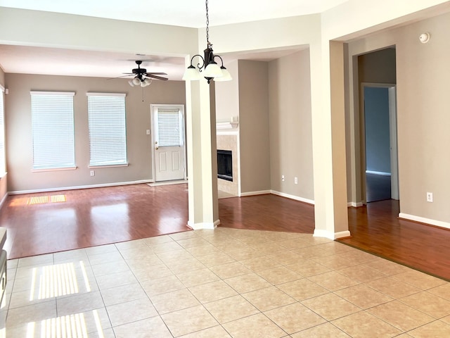 interior space featuring ceiling fan, light tile patterned floors, and a fireplace