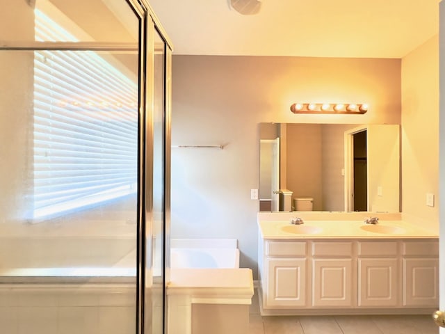 full bathroom featuring tile patterned flooring, vanity, shower with separate bathtub, and toilet