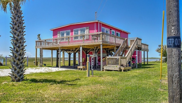 rear view of property with a wooden deck and a lawn