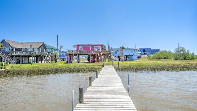 dock area with a water view and a yard