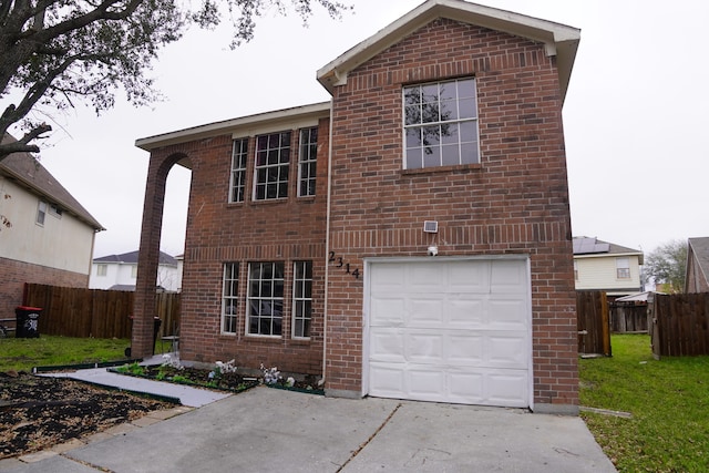 traditional-style house featuring a garage, brick siding, and fence