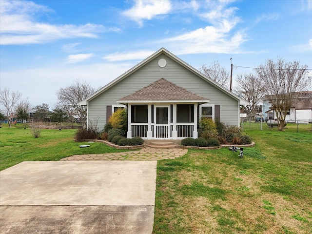 view of front of house featuring a shingled roof and a front yard