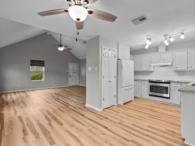 kitchen with visible vents, white cabinetry, open floor plan, stainless steel range with electric cooktop, and freestanding refrigerator