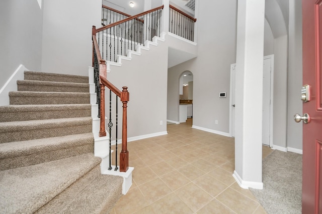 tiled foyer with a towering ceiling