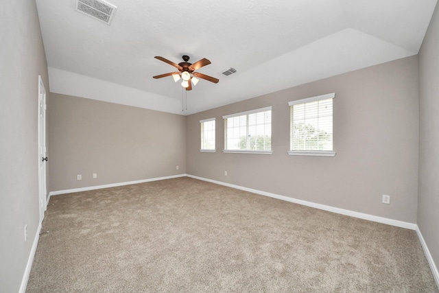 spare room with ceiling fan, lofted ceiling, a tray ceiling, and carpet floors