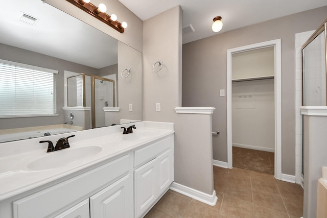 bathroom with tile patterned floors, independent shower and bath, and vanity