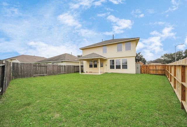 rear view of house featuring a yard and a patio