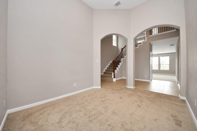 carpeted empty room with a towering ceiling