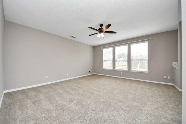 carpeted empty room featuring a textured ceiling and ceiling fan