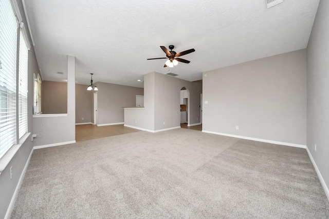 unfurnished living room featuring carpet floors, a textured ceiling, and ceiling fan